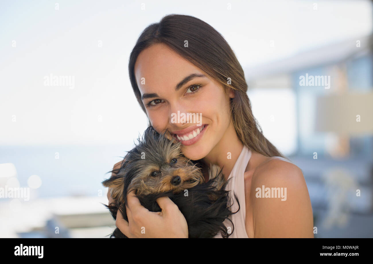 Portrait of smiling woman cuddling petit chien Banque D'Images