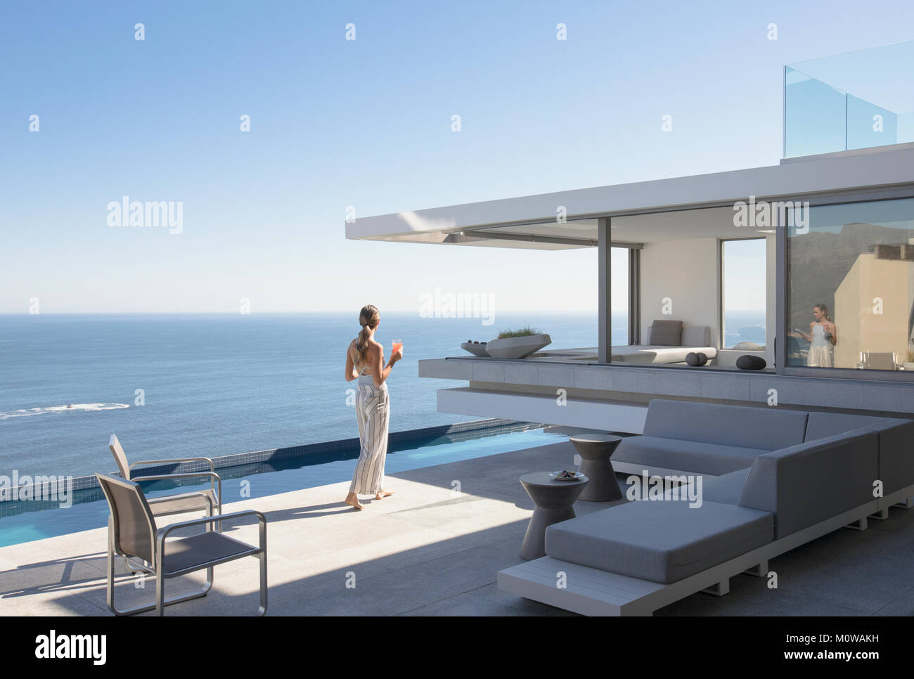 Sur femme moderne ensoleillée, luxury home vitrine patio extérieur avec vue sur l'océan Banque D'Images