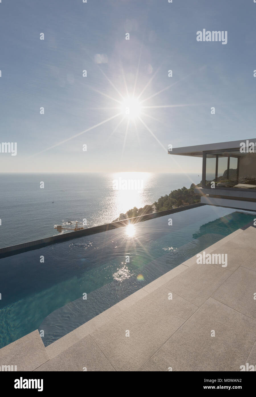 Avis de soleil sur l'océan et moderne de luxe, piscine extérieure home vitrine patio Banque D'Images