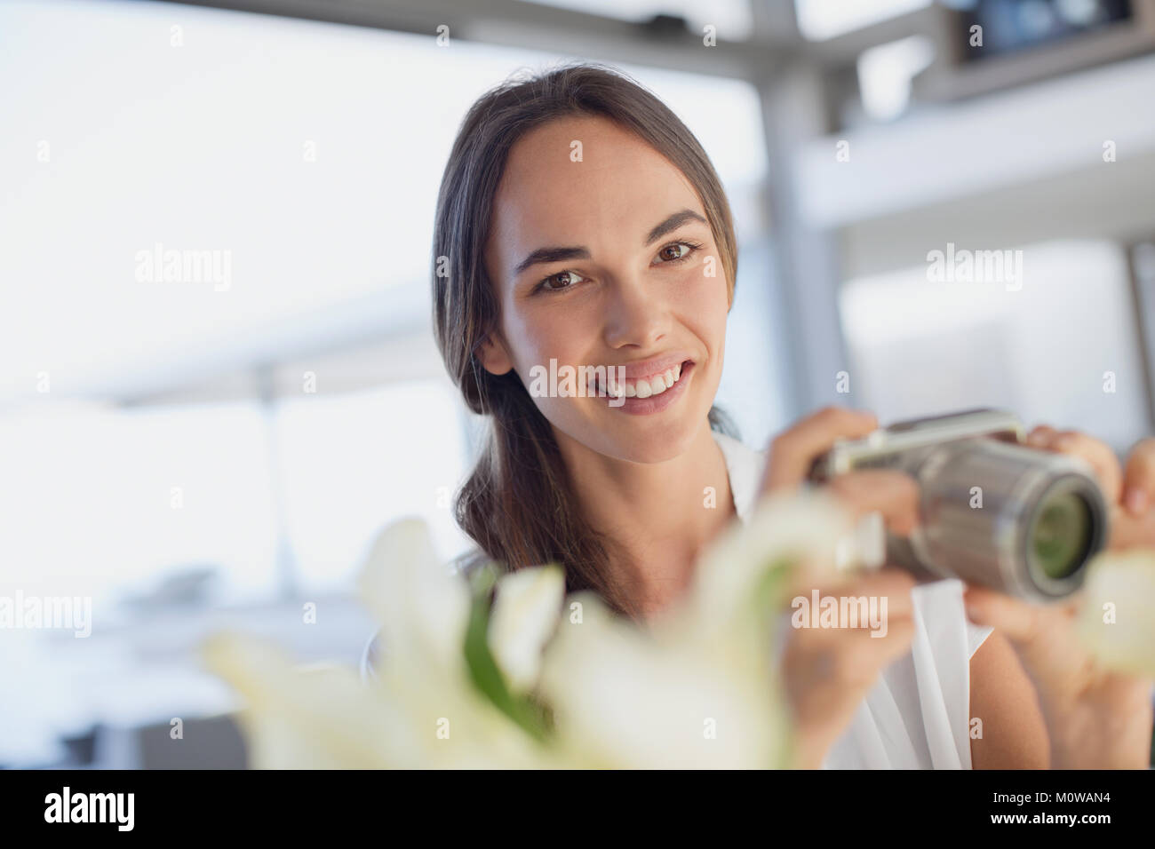 Portrait smiling brunette woman using digital camera Banque D'Images