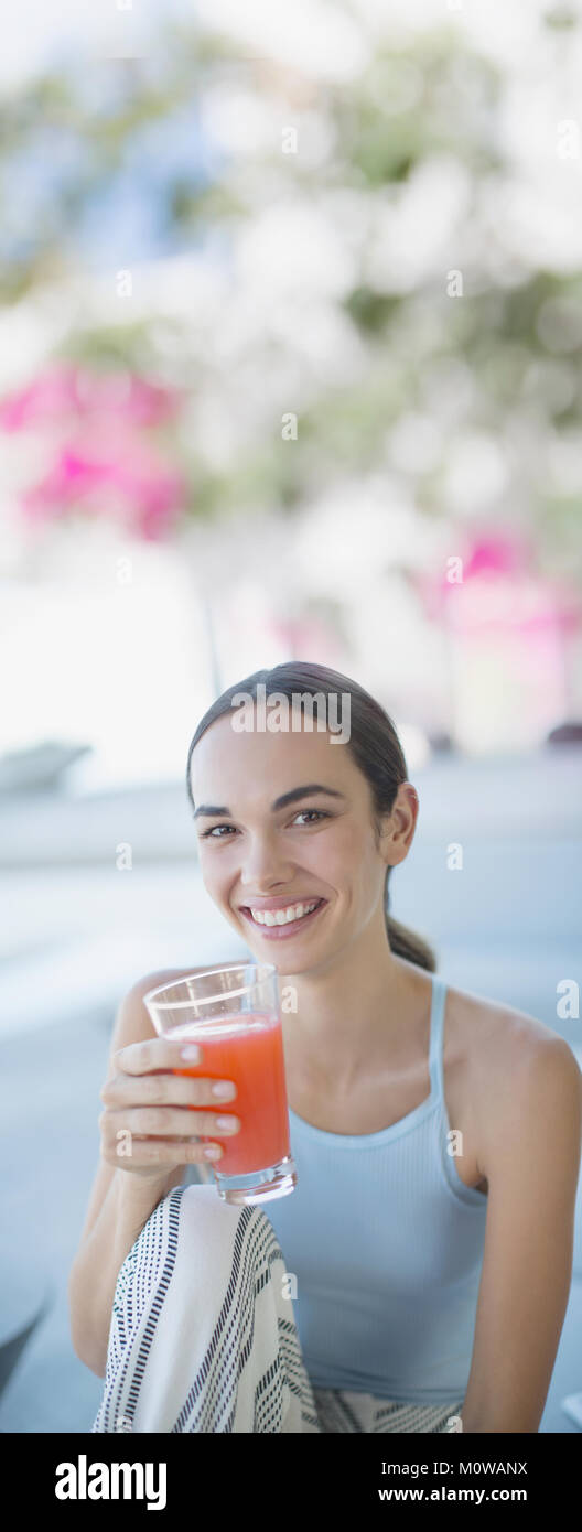 Portrait souriant, confiant brunette woman drinking juice Banque D'Images