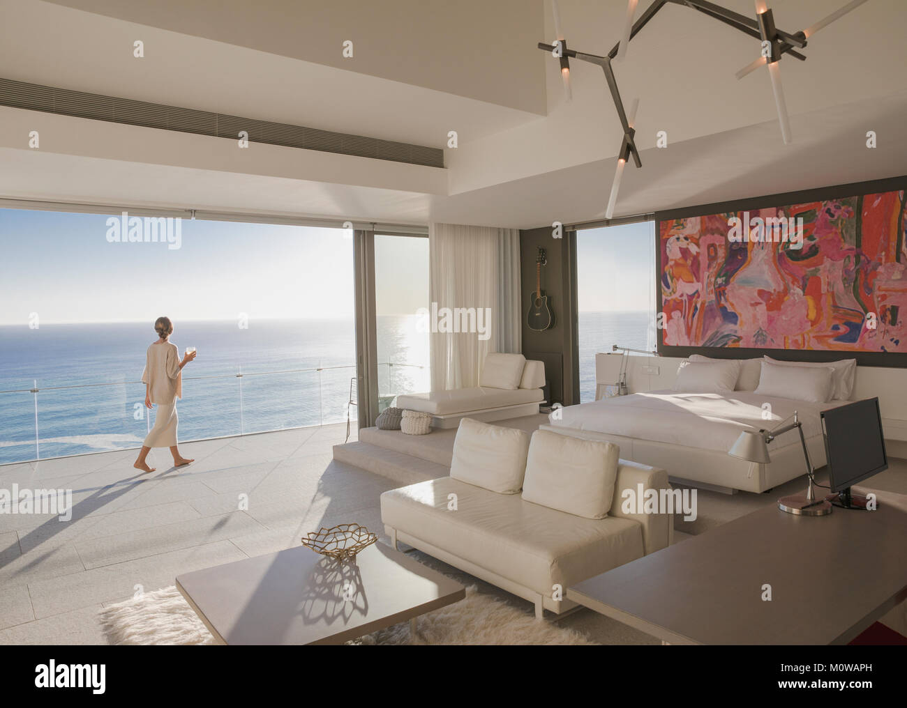Femme marche sur sunny, luxe moderne home vitrine chambre balcon avec vue sur l'océan Banque D'Images