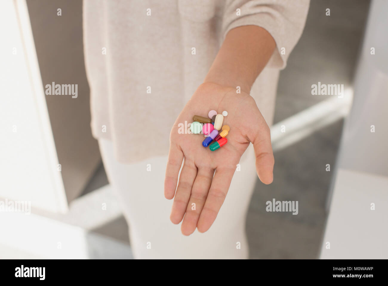Woman holding, montrant des pilules multicolores Banque D'Images