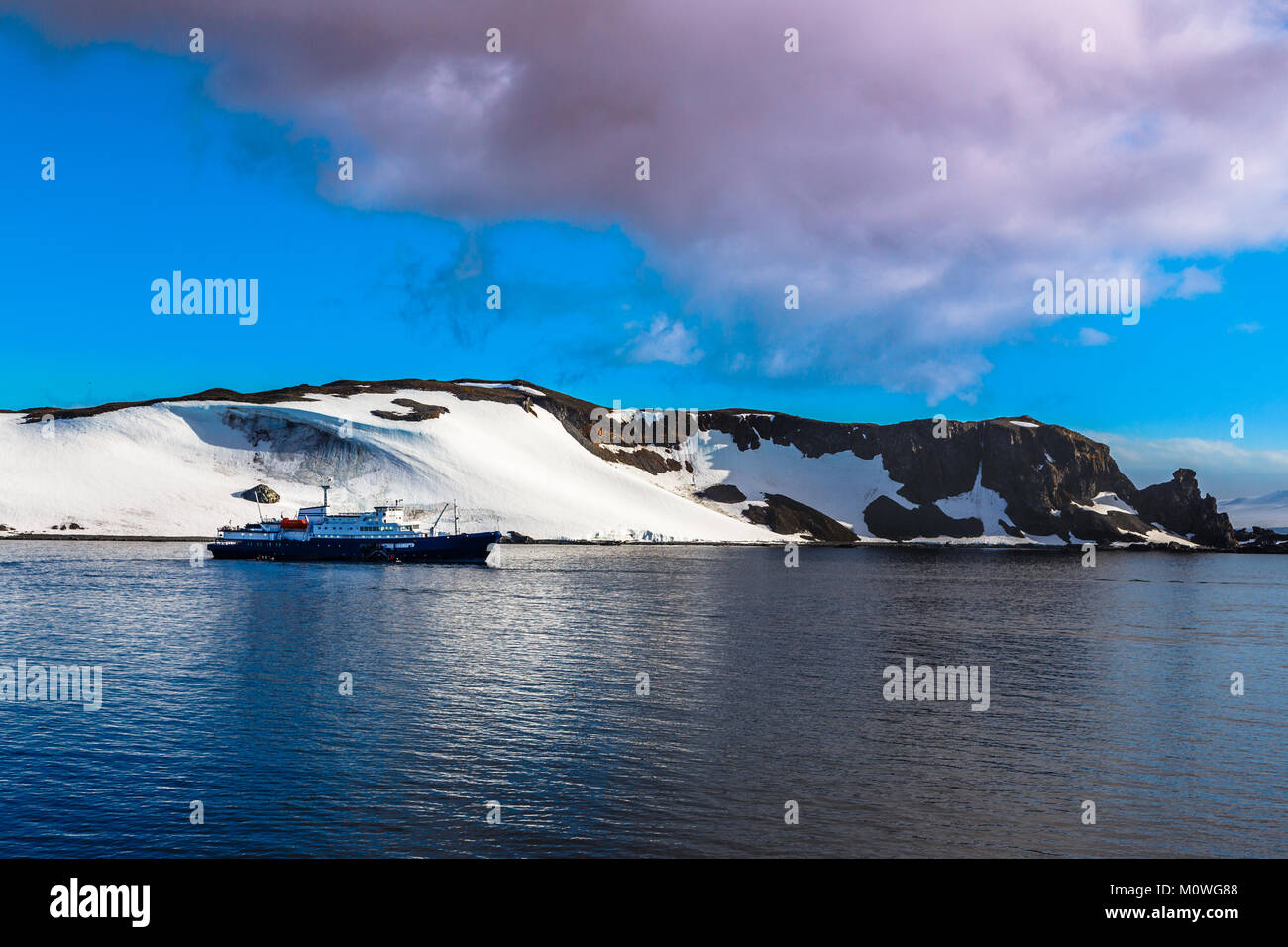 Bateau de croisière immobile sur la surface de la mer avec des montagnes enneigées en arrière-plan, près de la moitié de l'Antarctique, l'île de la Lune Banque D'Images