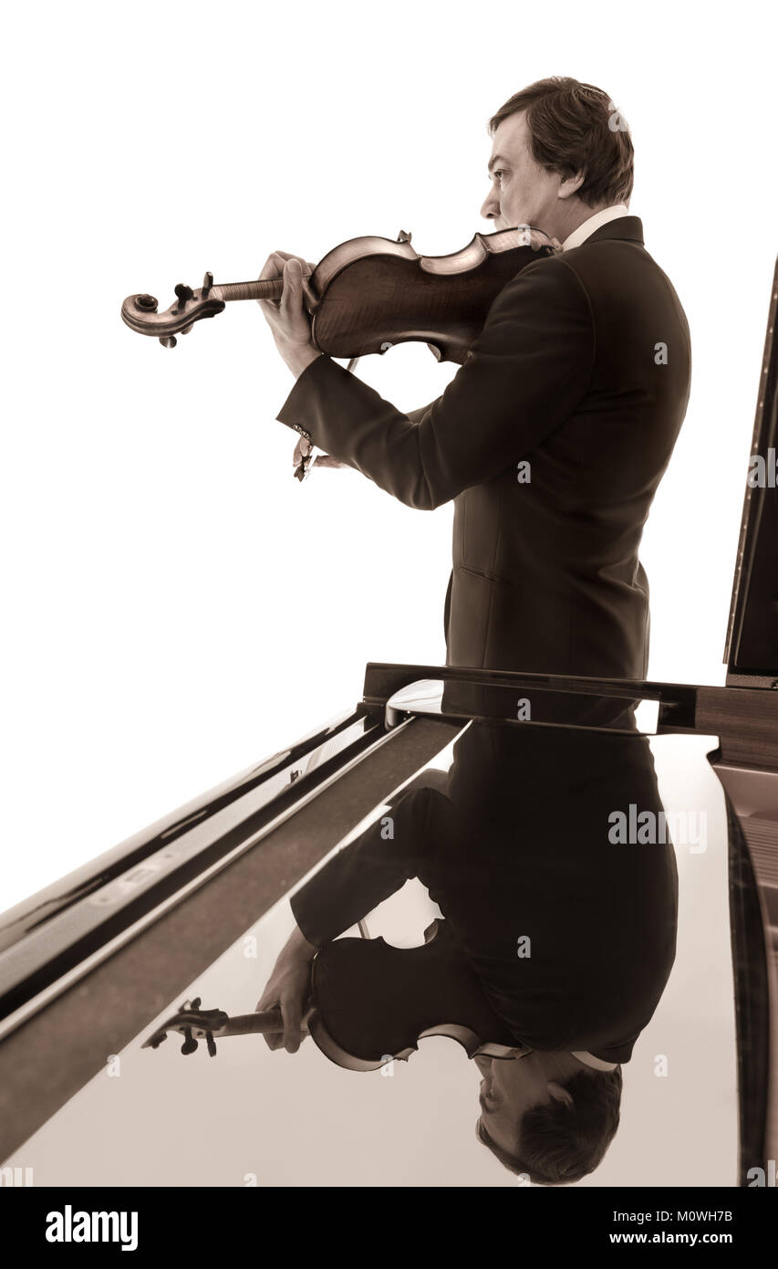 Senior male musician playing, alto ou alto, se reflète dans le brillant haut de grand piano Banque D'Images
