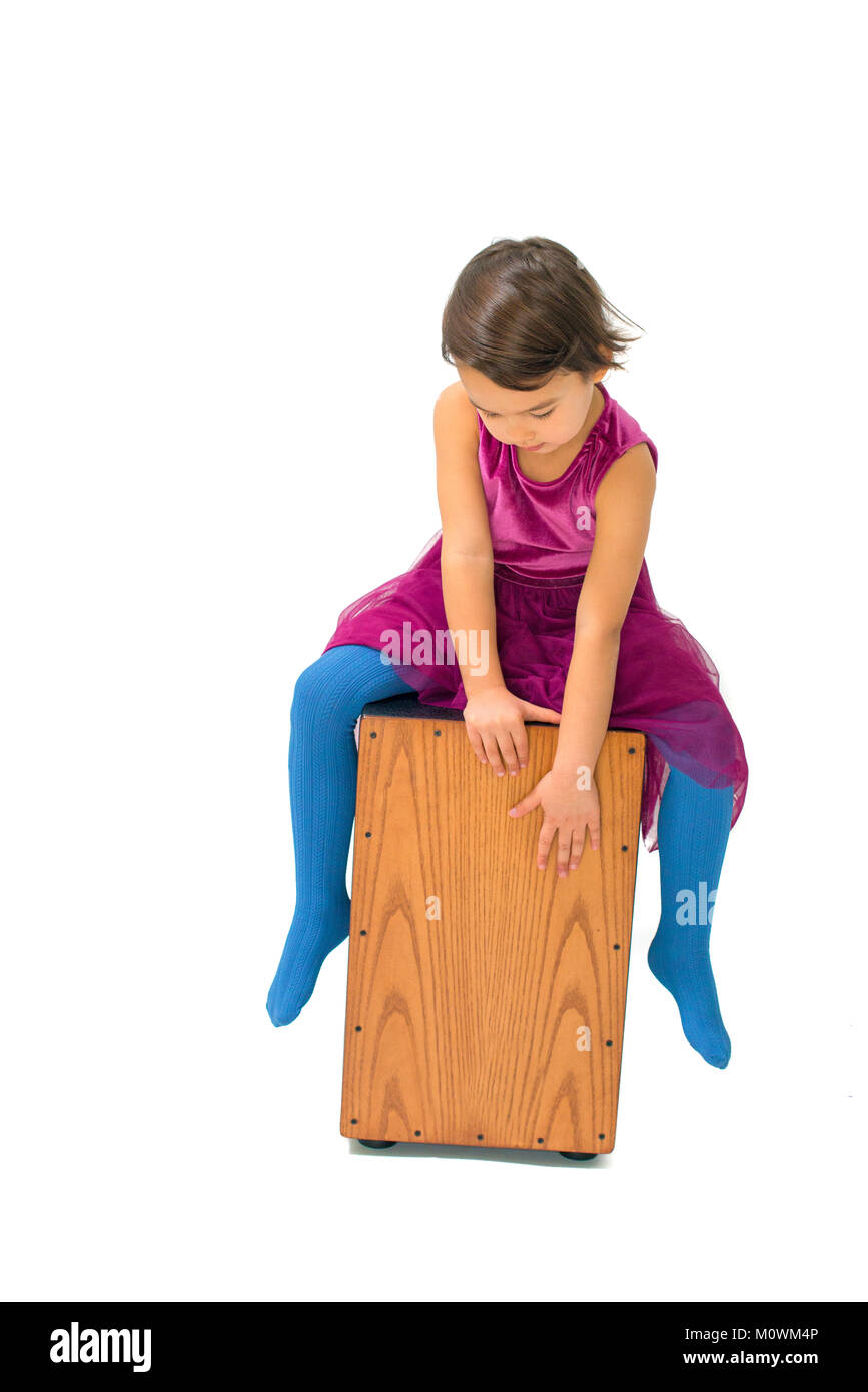 Petite fille jouant avec un Cajon isolé sur fond blanc Banque D'Images