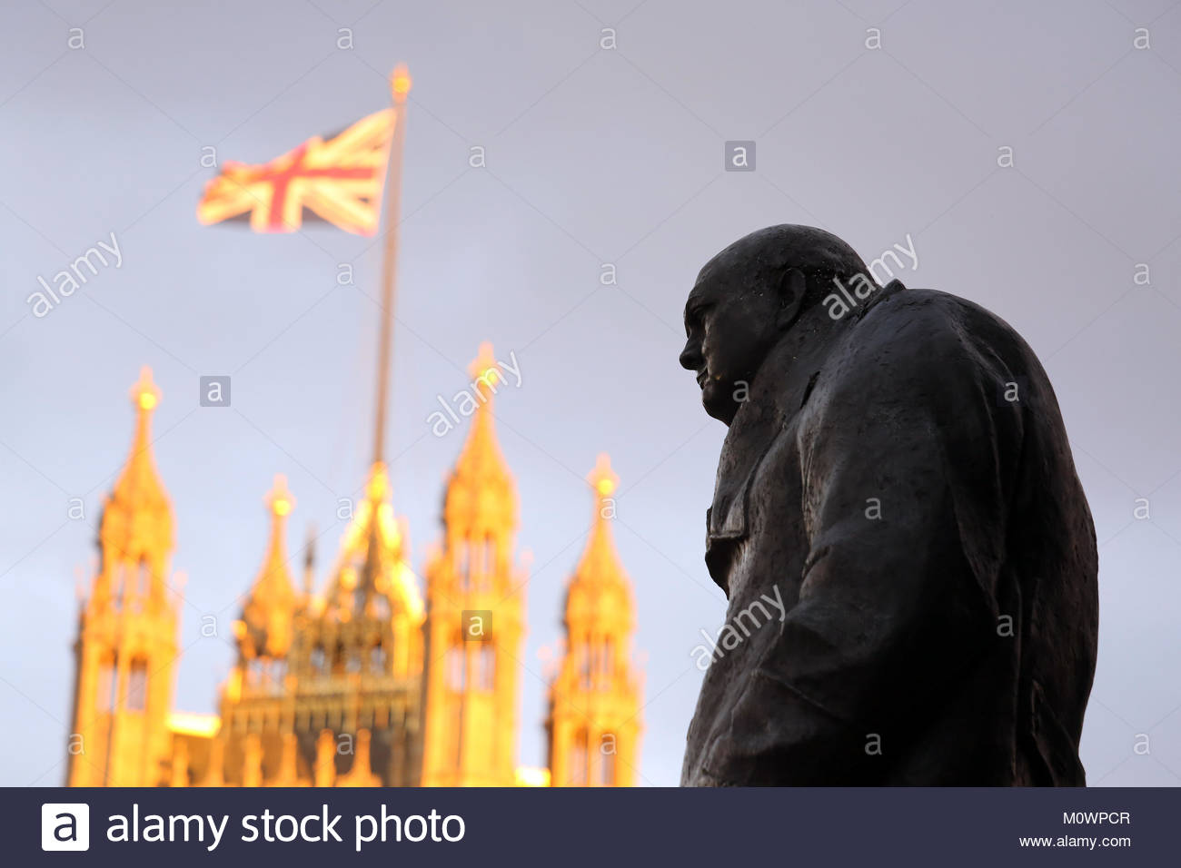 Un coucher du soleil sur Westminster montre une statue de Winston Churchill et de l'Union Jack et le Palais de Westminster après l'Brexit vote. Banque D'Images