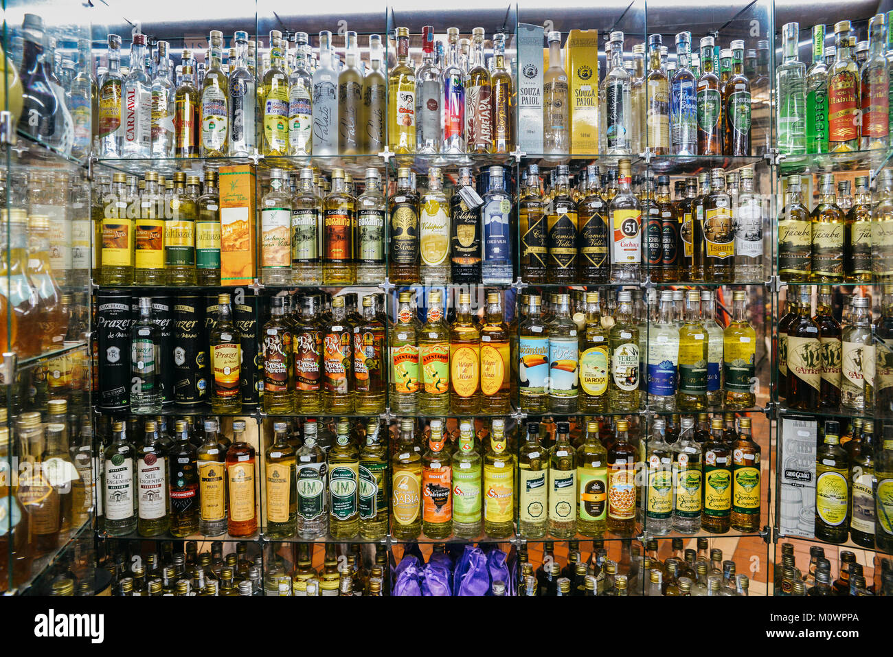 Lignes de différents types de verre cachaca, fabriqués à partir de canne à sucre distillée en vente à Belo Horizonte's Mercado Central Banque D'Images