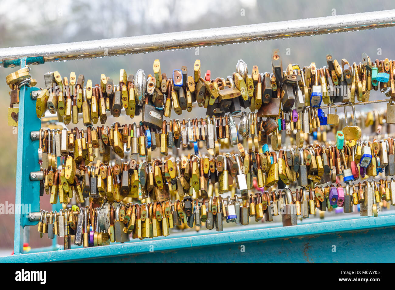 Collection de cadenas verrouillé sur pied d'un pont sur la rivière Wye sur un jour d'hiver pluvieux de la ville de Bakewell dans le Peak District de Derbyshire, Angleterre Banque D'Images