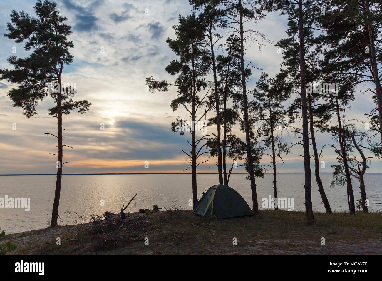 Une tente de couleur verte se trouve près de la forêt sur la rive. Tente à proximité de la forêt et l'eau. Banque D'Images