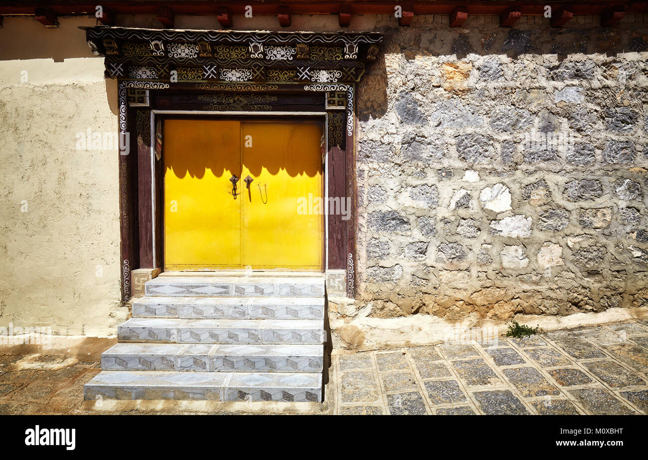 Mur de briques anciennes en pierre avec porte jaune, la Chine. Banque D'Images