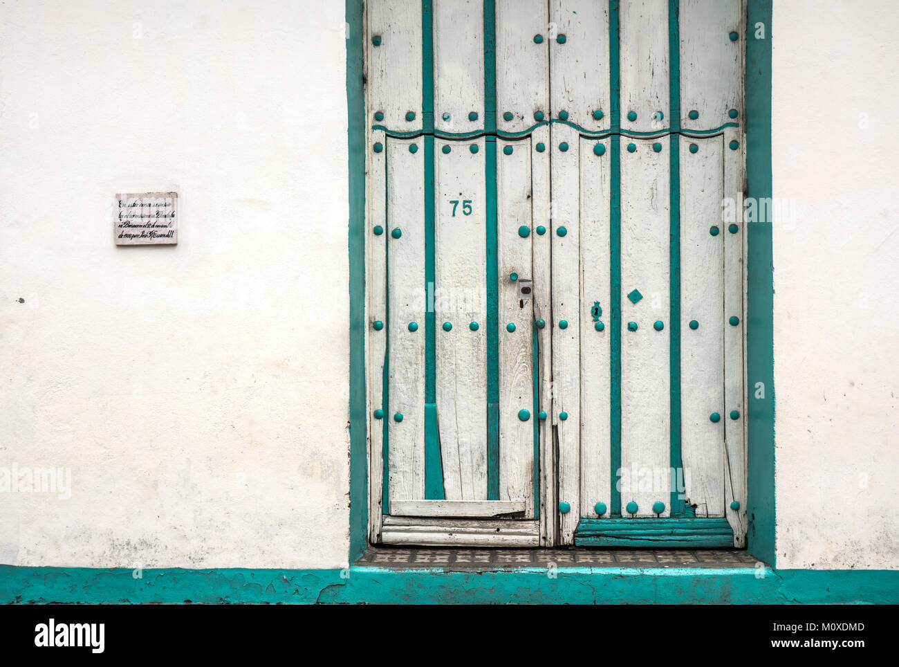Bâtiment colonial blanc avec porte et garniture verte à Baracoa, Cuba Banque D'Images