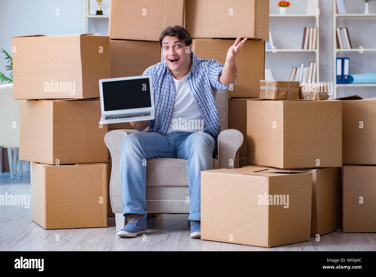 Jeune homme déménagement dans de nouvelles boîtes avec chambre Banque D'Images