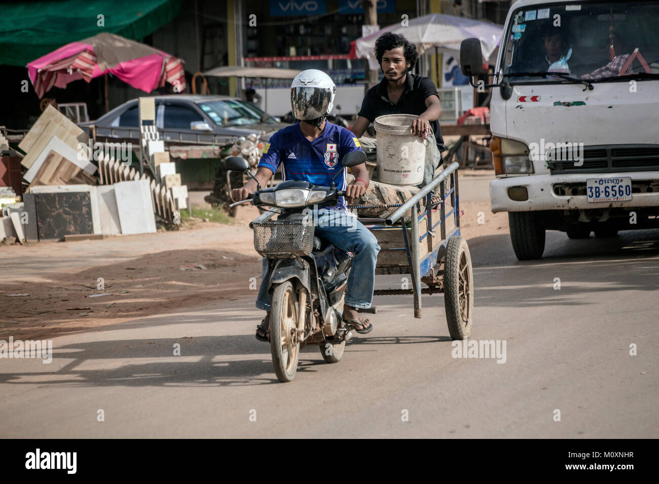 Équitation cambodgienne du cyclomoteur remorque Remorquage avec passager, Sangkat Chat Kouk, Krong Siem Reap, Cambodge. Banque D'Images