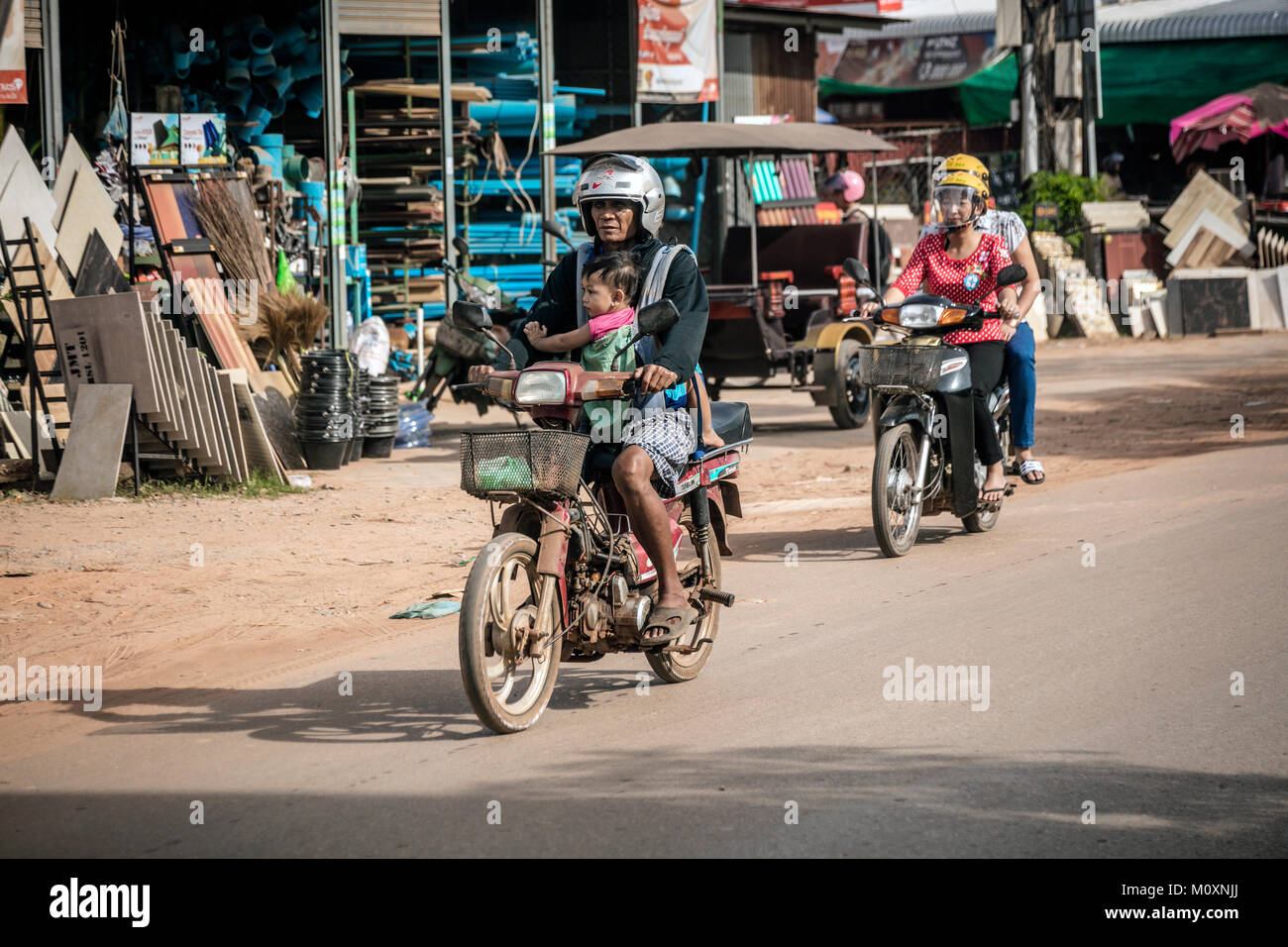 Équitation cambodgienne du cyclomoteur avec jeune enfant, Sangkat Chat Kouk, Krong Siem Reap, Cambodge. Banque D'Images