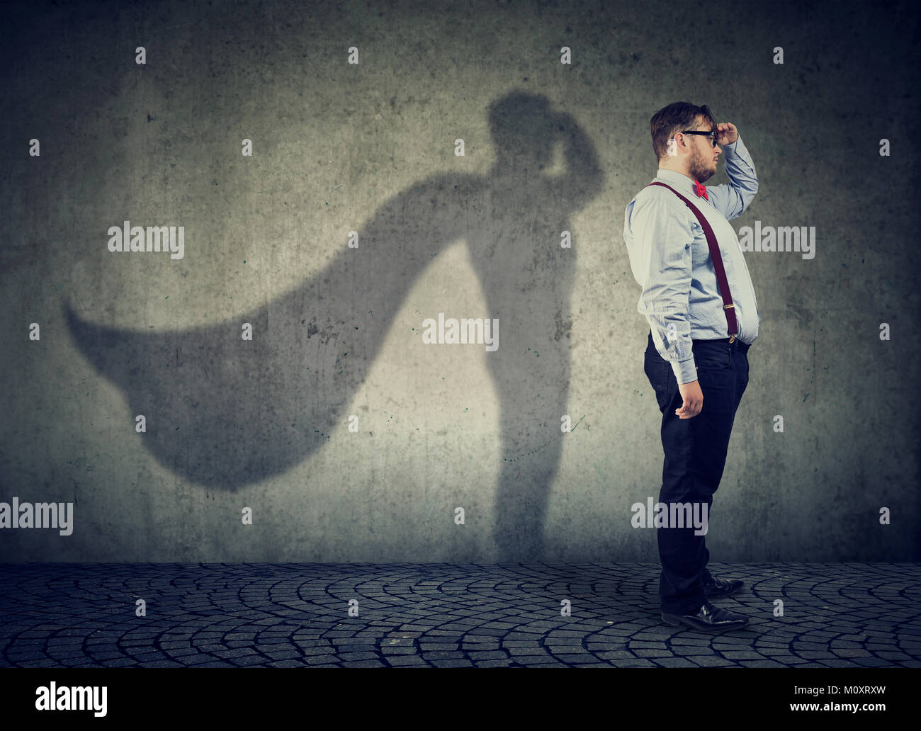 Vue latérale d'un homme grassouillet imaginer d'être super héros à aspirait. Banque D'Images