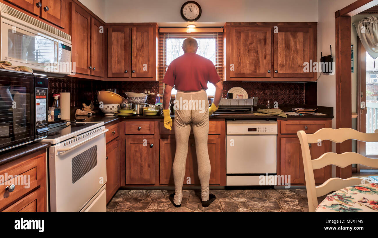 Un baccalauréat en homme en faisant la vaisselle dans l'évier de la cuisine. Banque D'Images