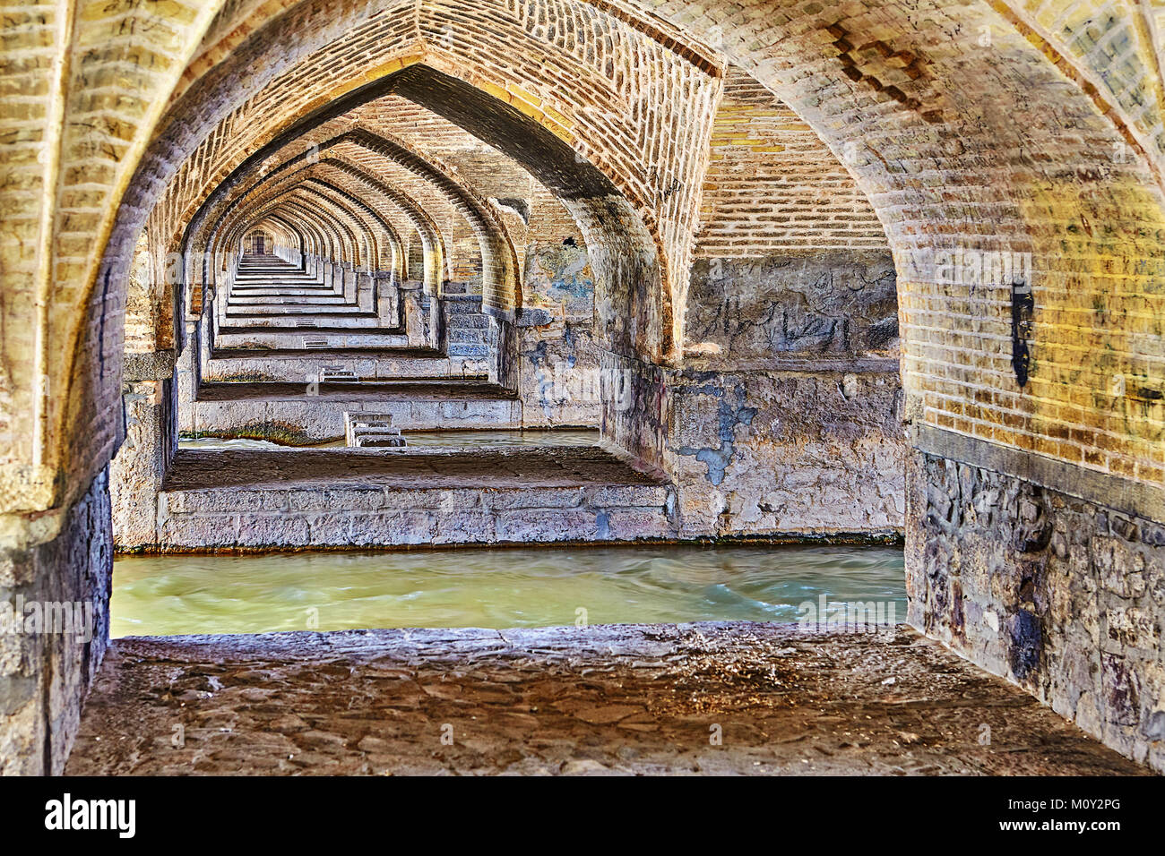 Voûtes en arc de brique sous un ancien pont Allahverdi Khan en pierre, Isfahan, Iran. Banque D'Images