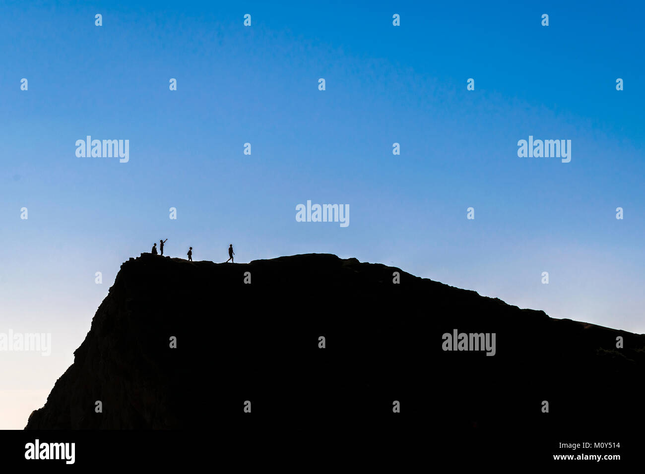 Silhouette contraste élevé scène paysage dépeignant des personnes en haut de la montagne à l'île de Chiloé, Chili Banque D'Images