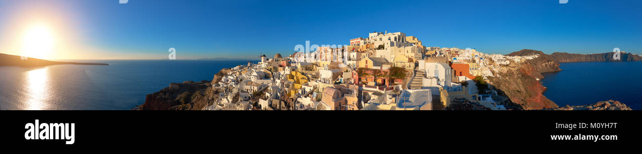 Coucher de soleil sur l'île de Santorin en Grèce. L'église traditionnelle, les appartements et les moulins à vent à Oia village sur une image panoramique, coucher du soleil Banque D'Images
