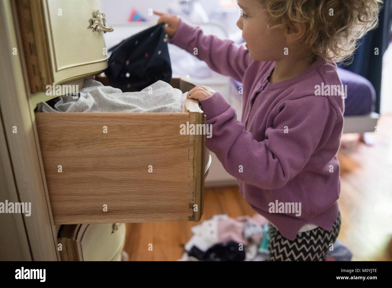 Caucasian girl dépose de vêtements à partir de tiroir Banque D'Images
