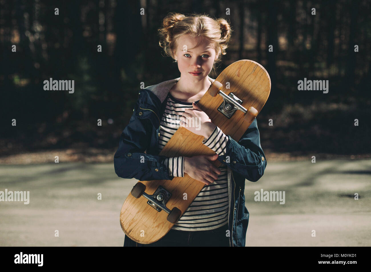 Portrait of Caucasian teenage girl holding skateboard Banque D'Images