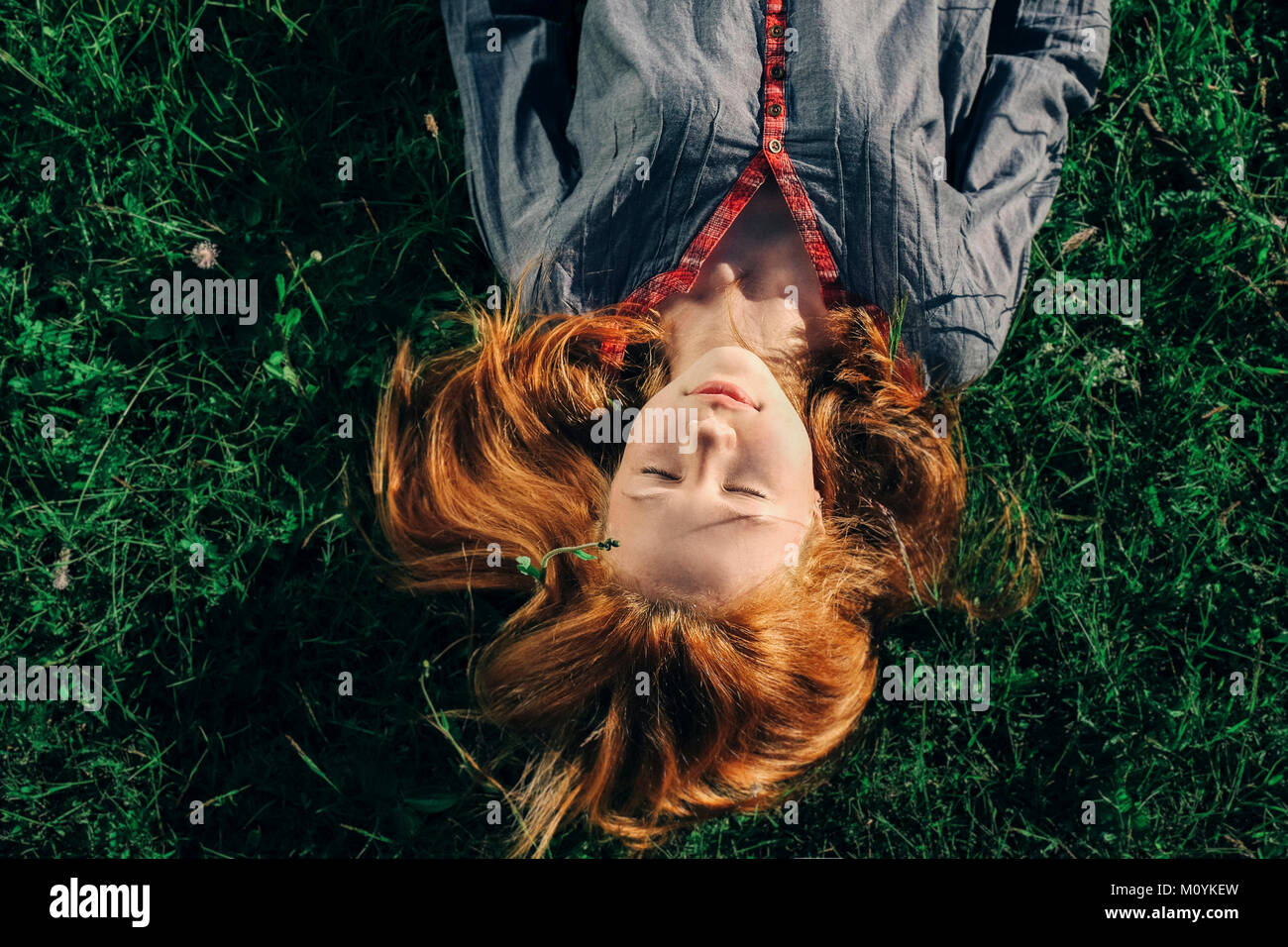 Caucasian woman laying in grass Banque D'Images