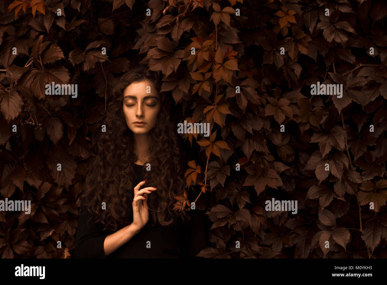 De graves Caucasian woman standing in les feuilles d'automne Banque D'Images