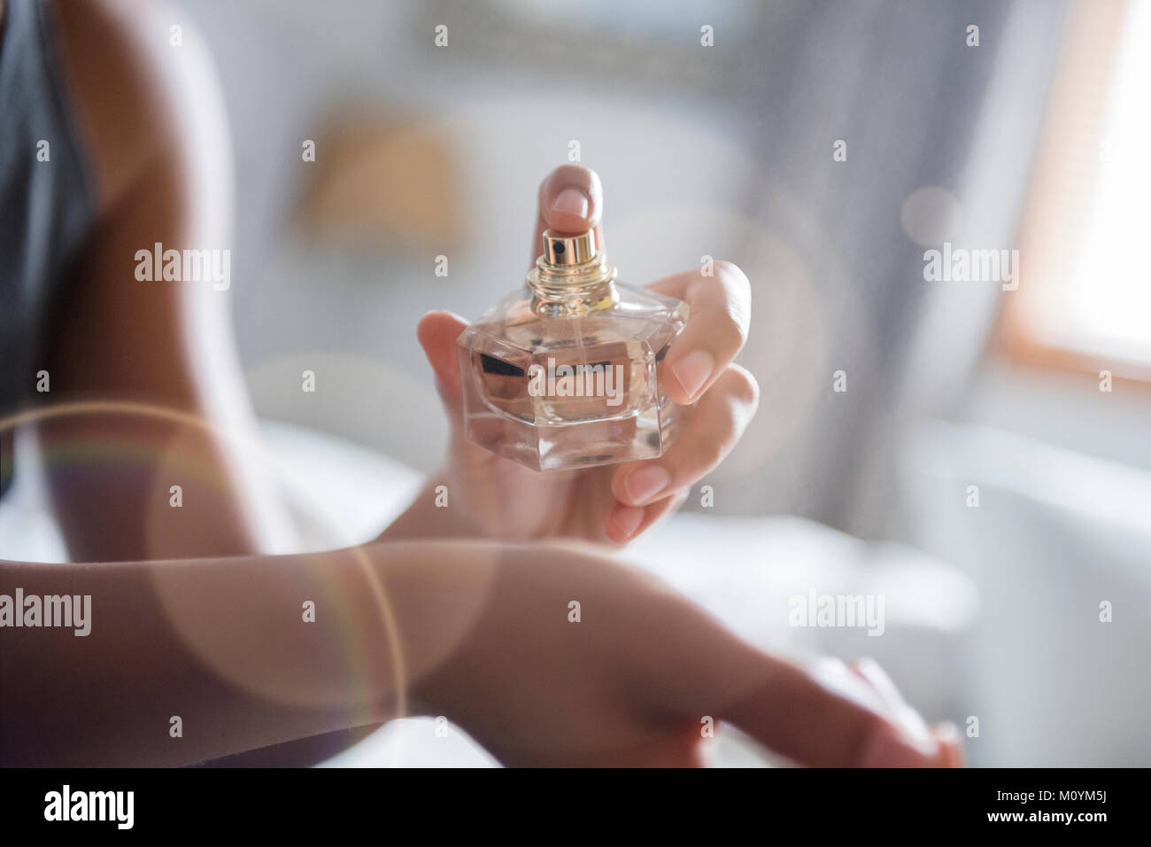 African American Woman spraying perfume sur poignet Banque D'Images