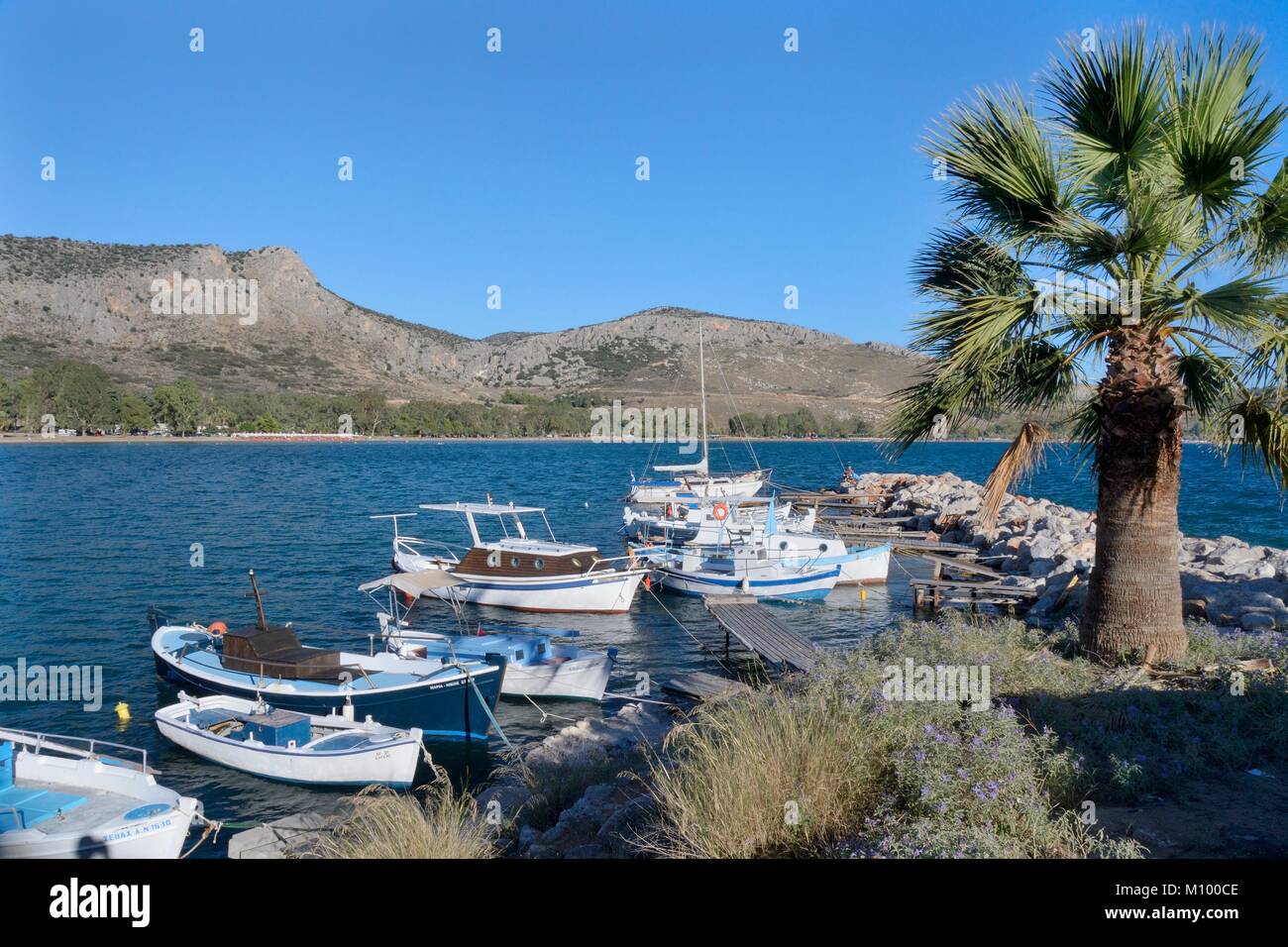 Les bateaux de pêche amarrés sur une jetée à l'extrémité de la baie de Karathona dans le golfe d'Argolide, Nauplie, près de l'Argolide, en Grèce, en juillet. Banque D'Images