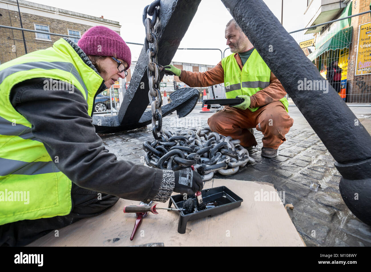 Londres, Royaume-Uni. 25 Jan, 2018. L'emblématique Deptford ancre est finalement remis à sa place d'origine à l'extrémité sud de Deptford High Street après avoir été retiré en 2013 pour des travaux de réaménagement de la rue. Vu ici à peindre sur sa nouvelle base pavée peu après avoir été soulevée. L'ancre fait partie de la riche histoire maritime de Deptford. Crédit : Guy Josse/Alamy Live News Banque D'Images