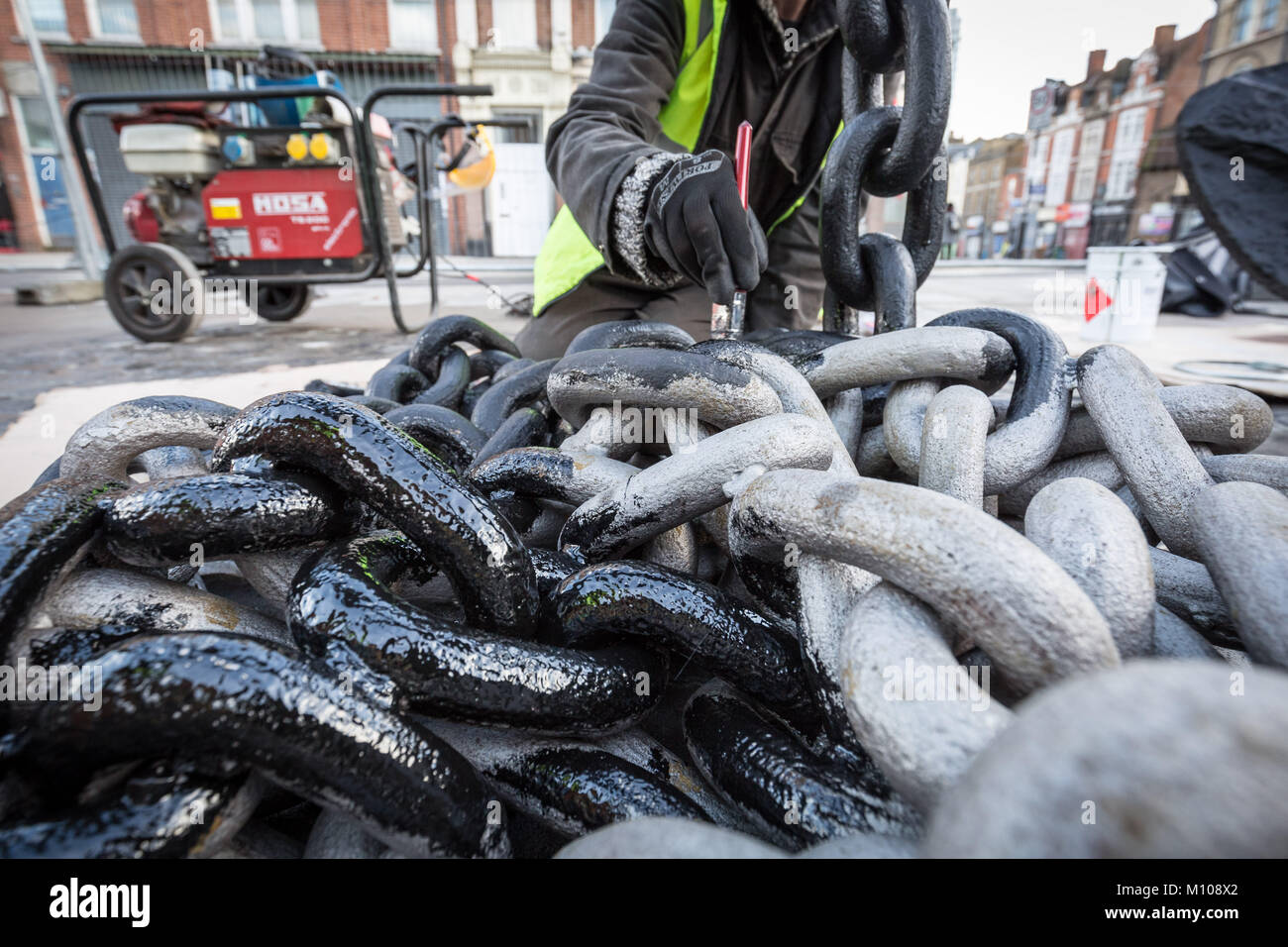 Londres, Royaume-Uni. 25 Jan, 2018. L'emblématique Deptford ancre est finalement remis à sa place d'origine à l'extrémité sud de Deptford High Street après avoir été retiré en 2013 pour des travaux de réaménagement de la rue. Vu ici à peindre sur sa nouvelle base pavée peu après avoir été soulevée. L'ancre fait partie de la riche histoire maritime de Deptford. Crédit : Guy Josse/Alamy Live News Banque D'Images