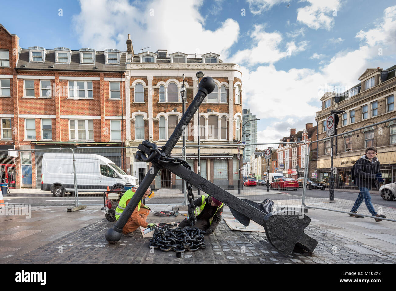 Londres, Royaume-Uni. 25 Jan, 2018. L'emblématique Deptford ancre est finalement remis à sa place d'origine à l'extrémité sud de Deptford High Street après avoir été retiré en 2013 pour des travaux de réaménagement de la rue. Vu ici à peindre sur sa nouvelle base pavée peu après avoir été soulevée. L'ancre fait partie de la riche histoire maritime de Deptford. Crédit : Guy Josse/Alamy Live News Banque D'Images