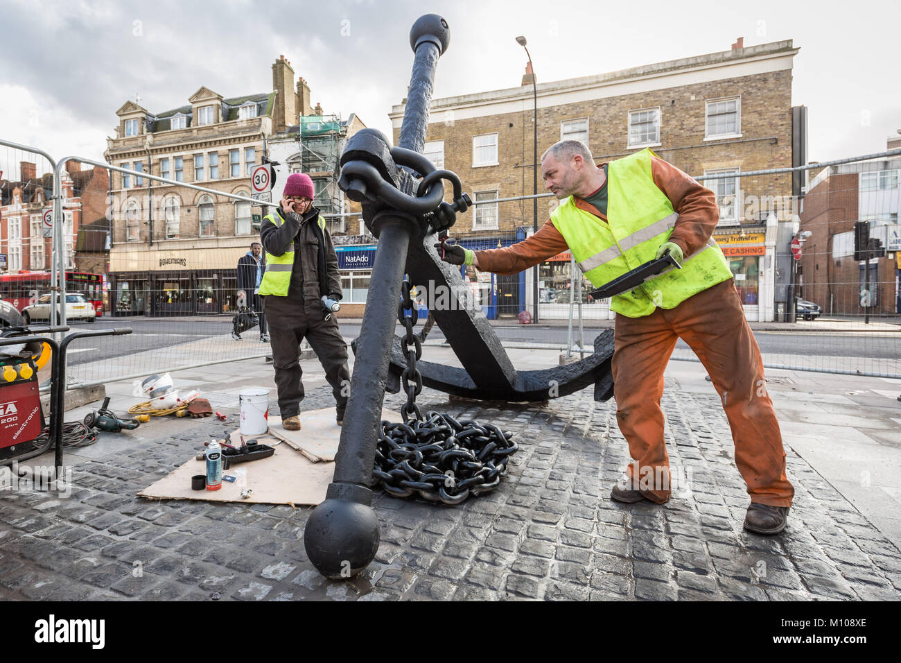 Londres, Royaume-Uni. 25 Jan, 2018. L'emblématique Deptford ancre est finalement remis à sa place d'origine à l'extrémité sud de Deptford High Street après avoir été retiré en 2013 pour des travaux de réaménagement de la rue. Vu ici à peindre sur sa nouvelle base pavée peu après avoir été soulevée. L'ancre fait partie de la riche histoire maritime de Deptford. Crédit : Guy Josse/Alamy Live News Banque D'Images