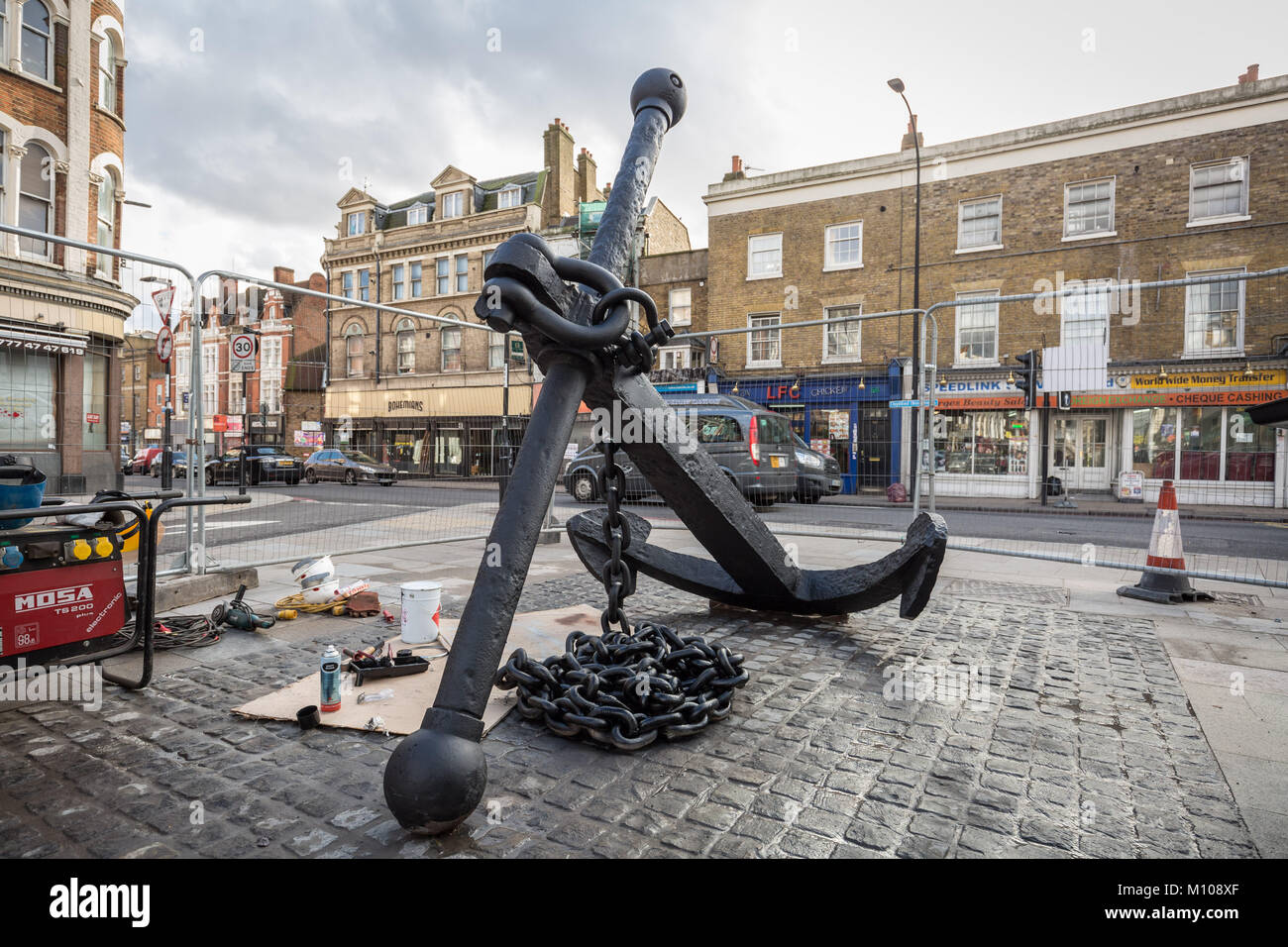 Londres, Royaume-Uni. 25 Jan, 2018. L'emblématique Deptford ancre est finalement remis à sa place d'origine à l'extrémité sud de Deptford High Street après avoir été retiré en 2013 pour des travaux de réaménagement de la rue. Vu ici à peindre sur sa nouvelle base pavée peu après avoir été soulevée. L'ancre fait partie de la riche histoire maritime de Deptford. Crédit : Guy Josse/Alamy Live News Banque D'Images