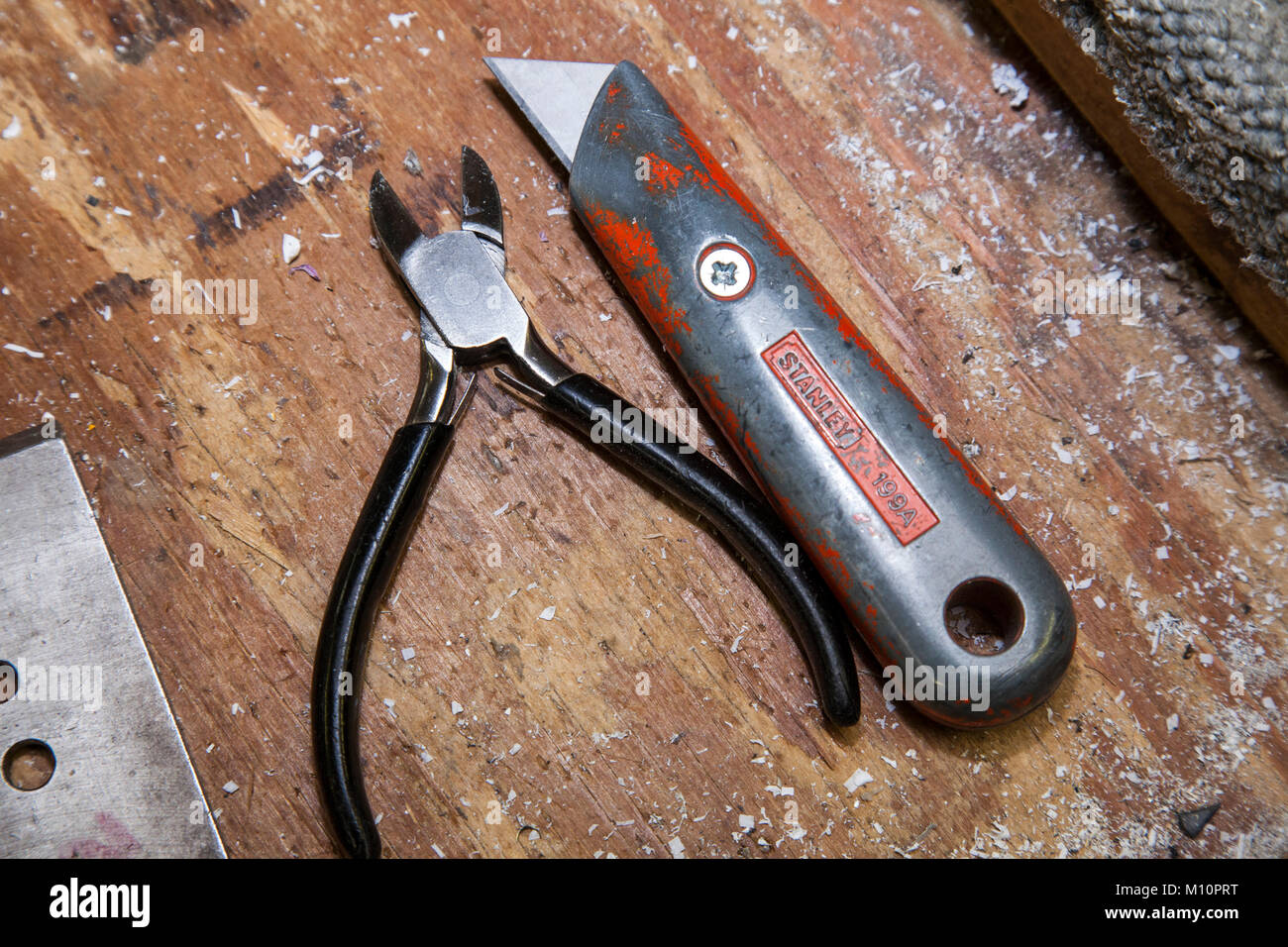 Ferblantier d'une pince et d'un couteau Stanley cutter sur un banc en bois. Banque D'Images