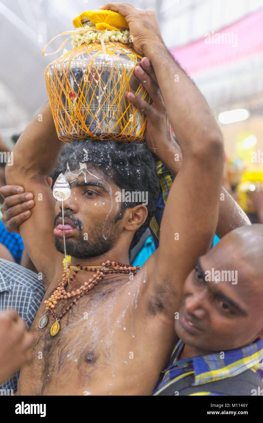 Singapour 2015 : passionnés d'Hindu obtenir percé dans leur bouche avec une aiguille et de transporter le lait pot pour le Seigneur Muruga lors des festival hindou Thaipusam Banque D'Images