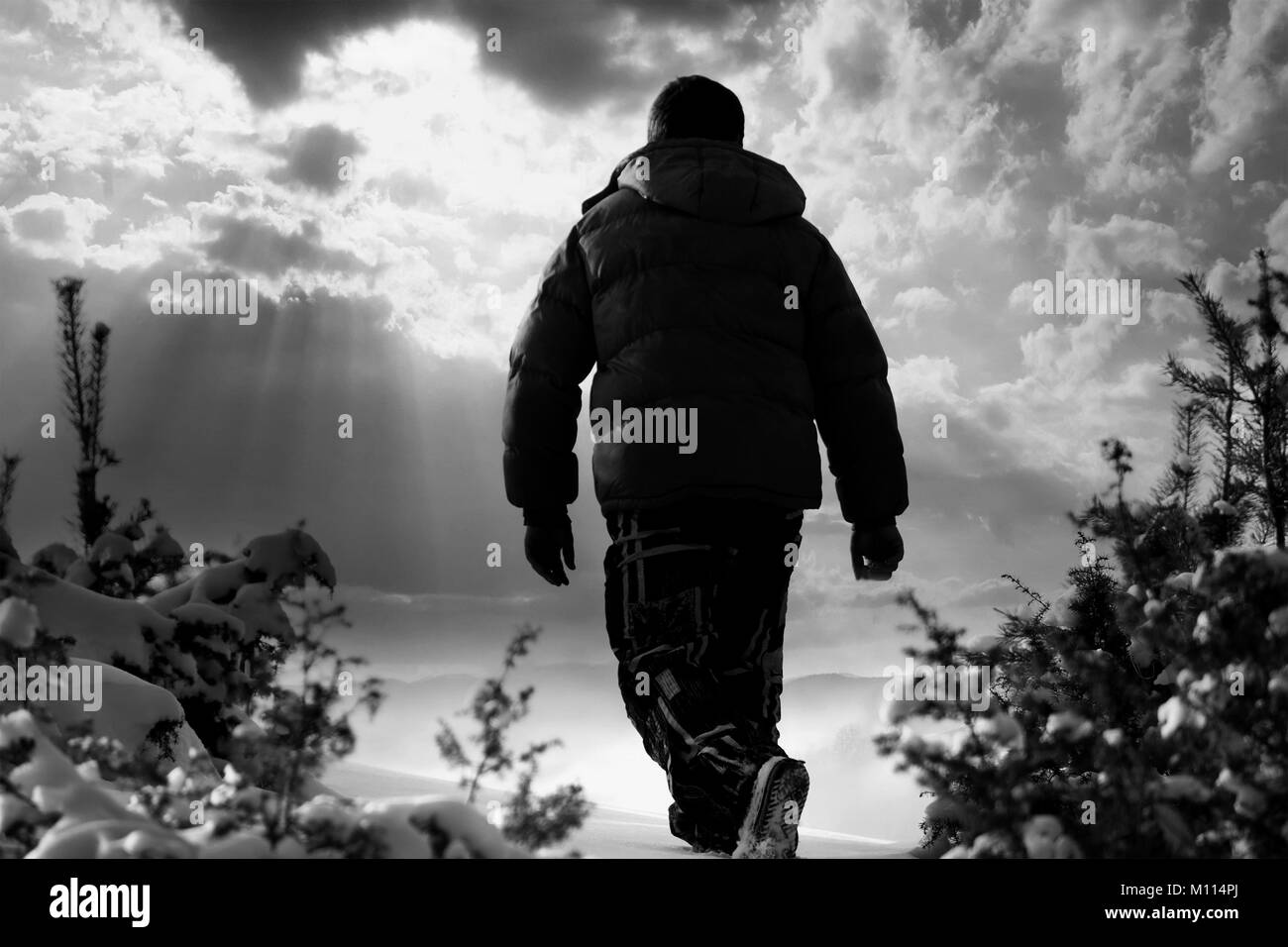 Paysage en noir et blanc à l'homme marchant dans les montagnes de neige Banque D'Images