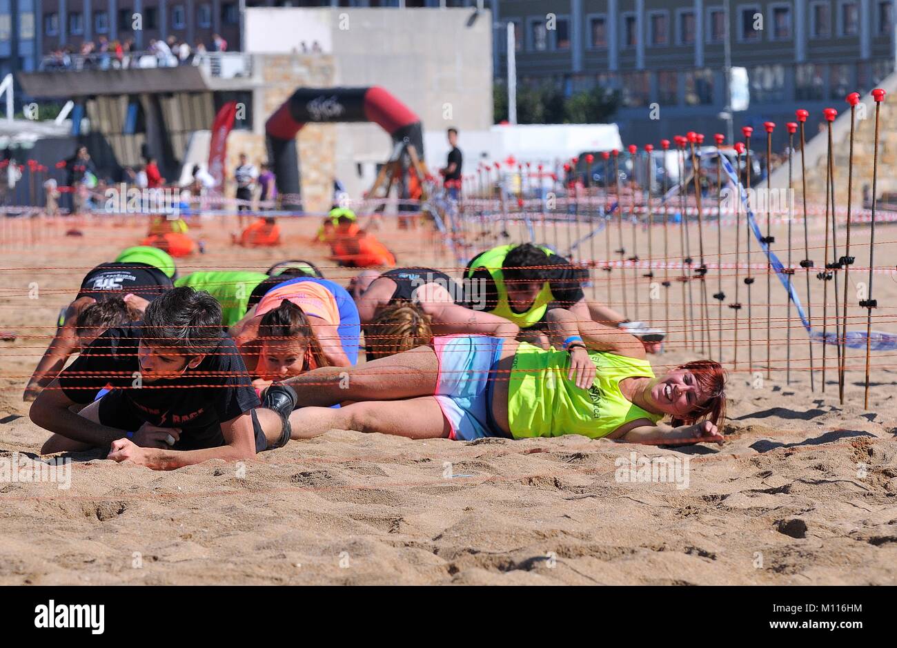 GIJON, ESPAGNE - 19 SEPTEMBRE : Storm Race, un parcours extrême en Septembre 19, 2015 à Gijon, Espagne. Porteur rampé sous le fil. Banque D'Images