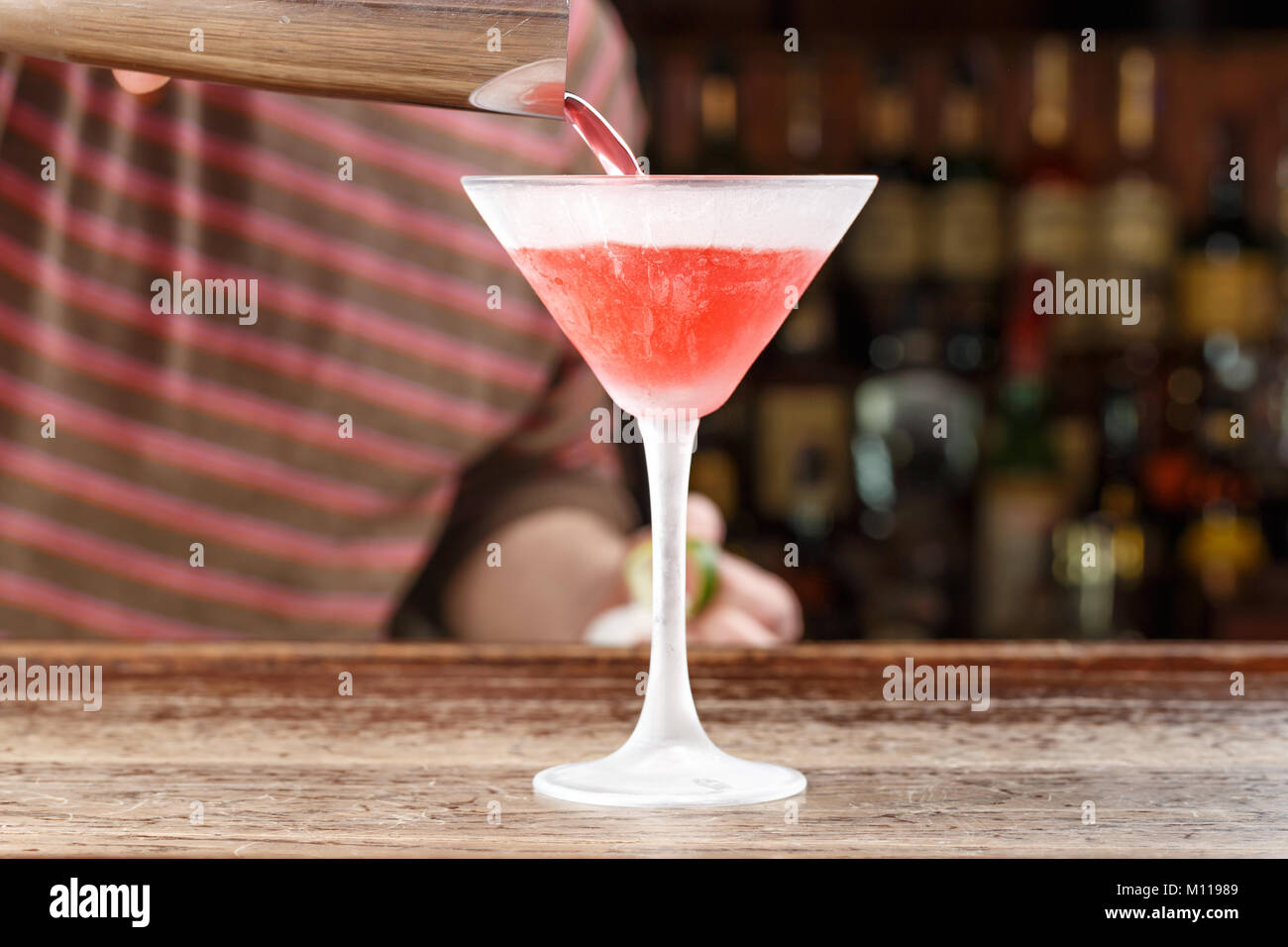 Cocktail Cosmopolitan, le barman se déverse sur le bar. Cocktail sur la base de vodka, de triple-sec, liqueur de citron et jus de canneberge. Un espace réservé au texte Banque D'Images