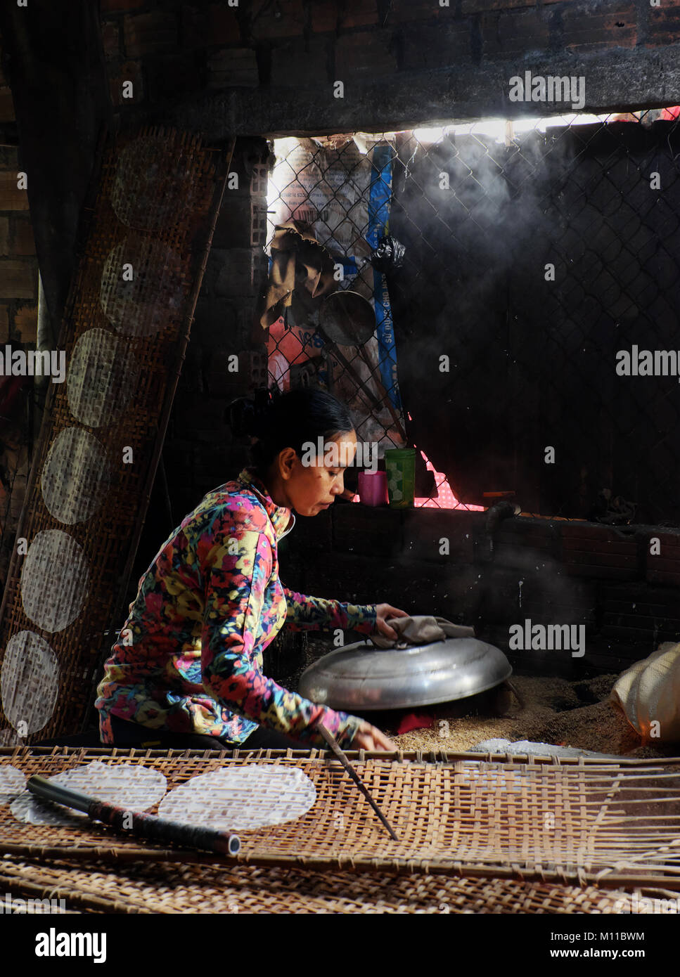 BINH DINH, LE VIET NAM, vietnamienne s'asseoir et travailler à la maison, femme d'origine asiatique faire du papier de riz, une cuisine traditionnelle à partir de farine de riz, gâteau de ceinture Banque D'Images