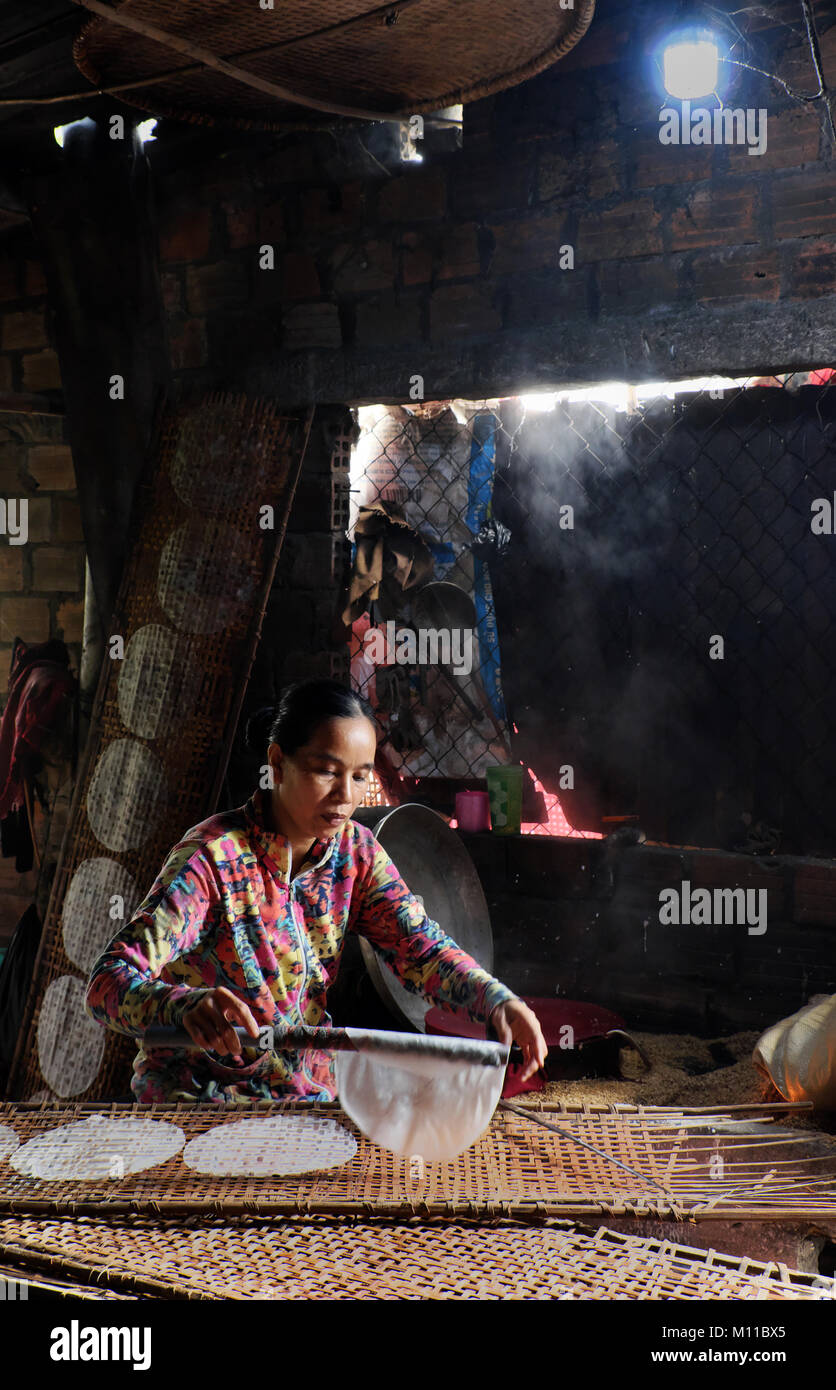 BINH DINH, LE VIET NAM, vietnamienne s'asseoir et travailler à la maison, femme d'origine asiatique faire du papier de riz, une cuisine traditionnelle à partir de farine de riz, gâteau de ceinture Banque D'Images