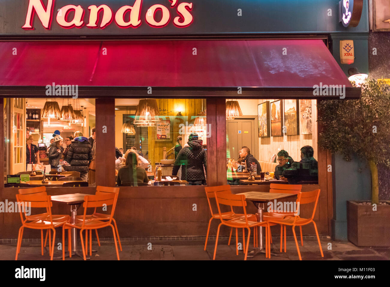 Nando's la nuit. Clients assis dans le restaurant comme le crépuscule