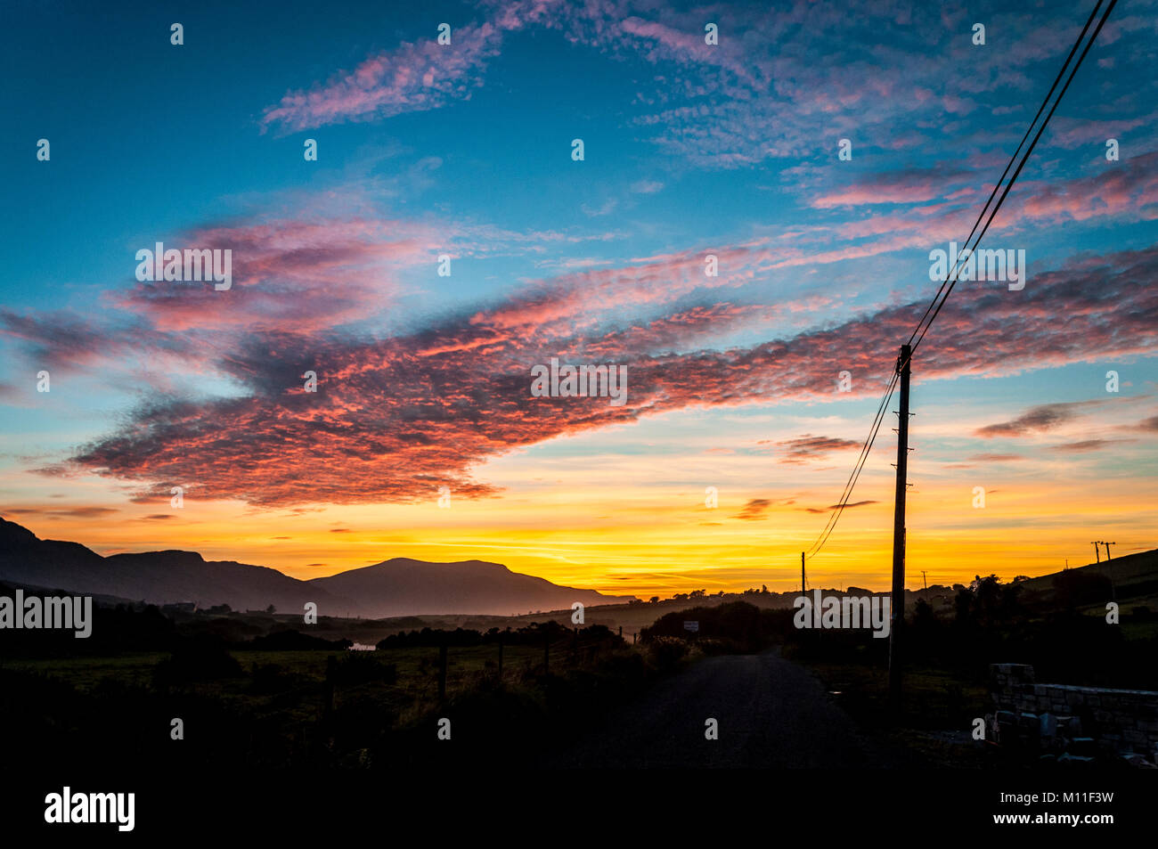 Coucher du soleil et ESB sur des poteaux électriques, Ardara, comté de Donegal, Irlande. Banque D'Images