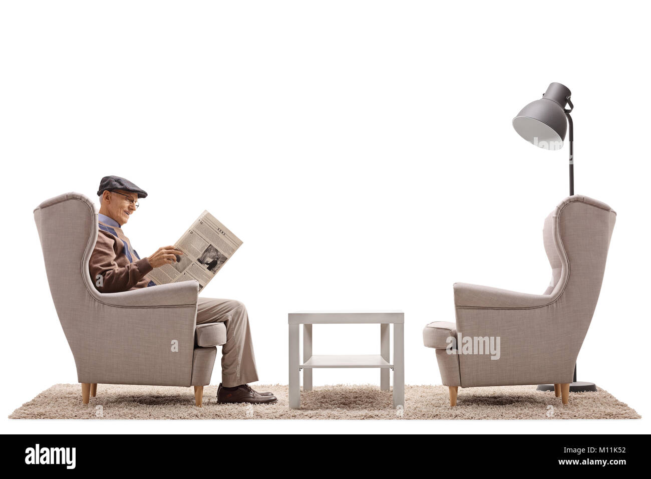 Hauts assise sur un fauteuil et de lire un journal isolé sur fond blanc Banque D'Images
