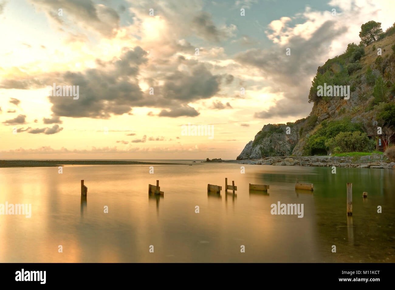 Palinuro. Fleuve Mingardo bouche à l'aube avec ciel nuageux et dans l'arrière-plan la roche mingardo et le promontoire en direction de Marina di Camerota Banque D'Images