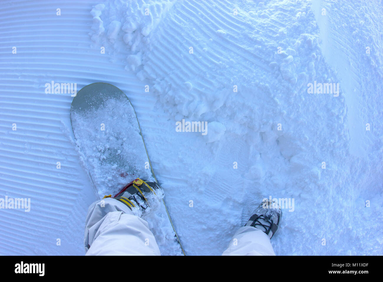 Une prise d'un surfeur debout sur la piste de neige prêt à rouler Banque D'Images