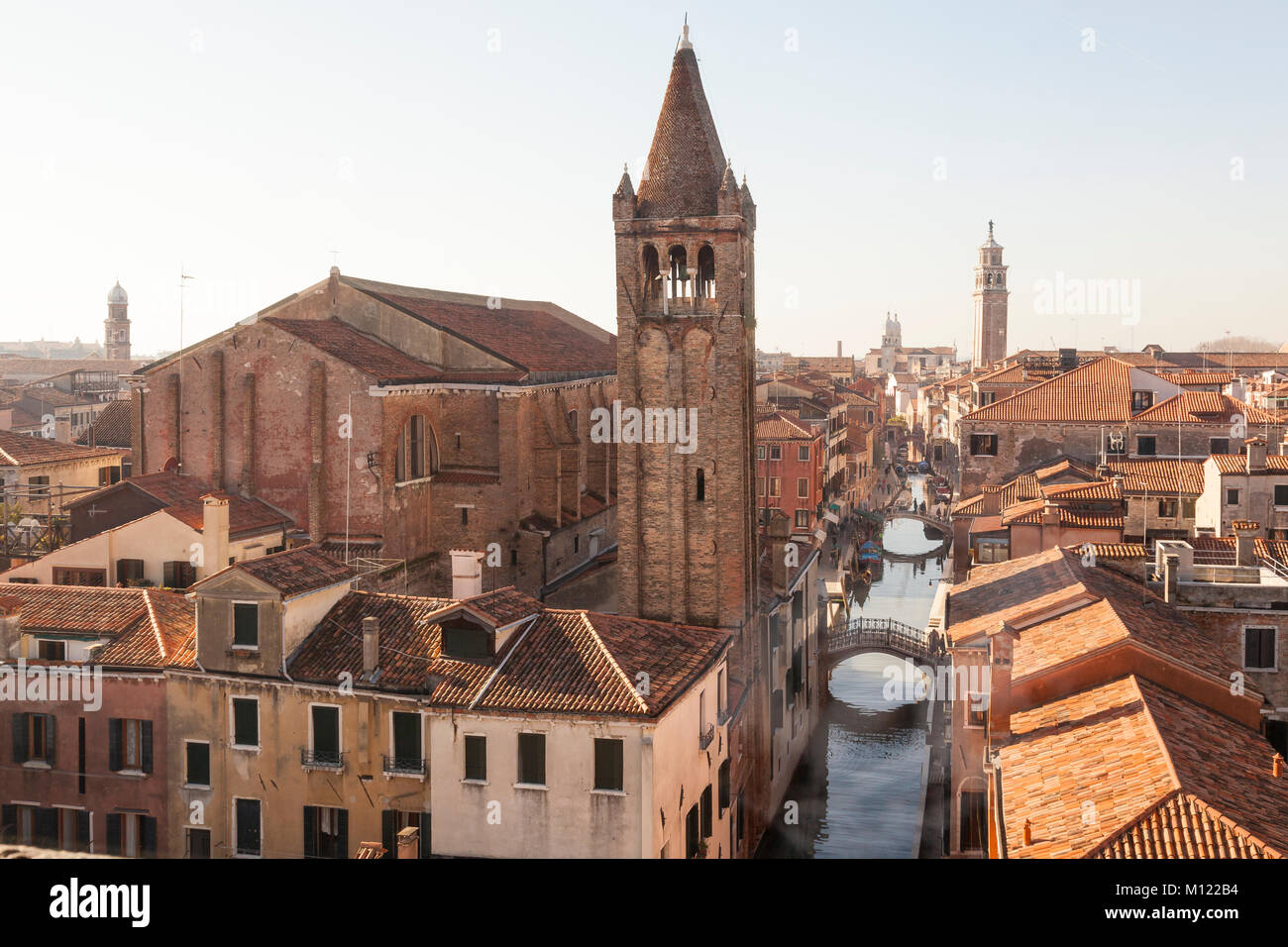 Vue sur le toit plus de Rio de San Barnaba canal, l'église San Barnaba et campanile et Dorsoduro, Venise, Vénétie, Italie en hiver soleil avec léger brouillard Banque D'Images