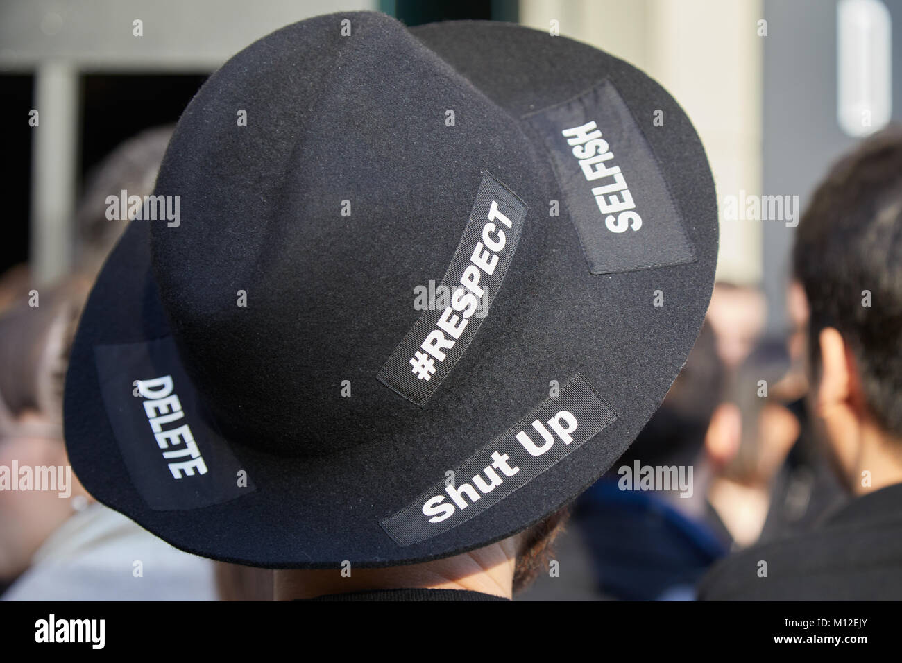 MILAN - le 14 janvier : Homme avec chapeau noir avec des mots écrits supprimer, égoïste, jusqu'à l'arrêt avant Daks fashion show, Milan Fashion Week street style le 08 janvier Banque D'Images