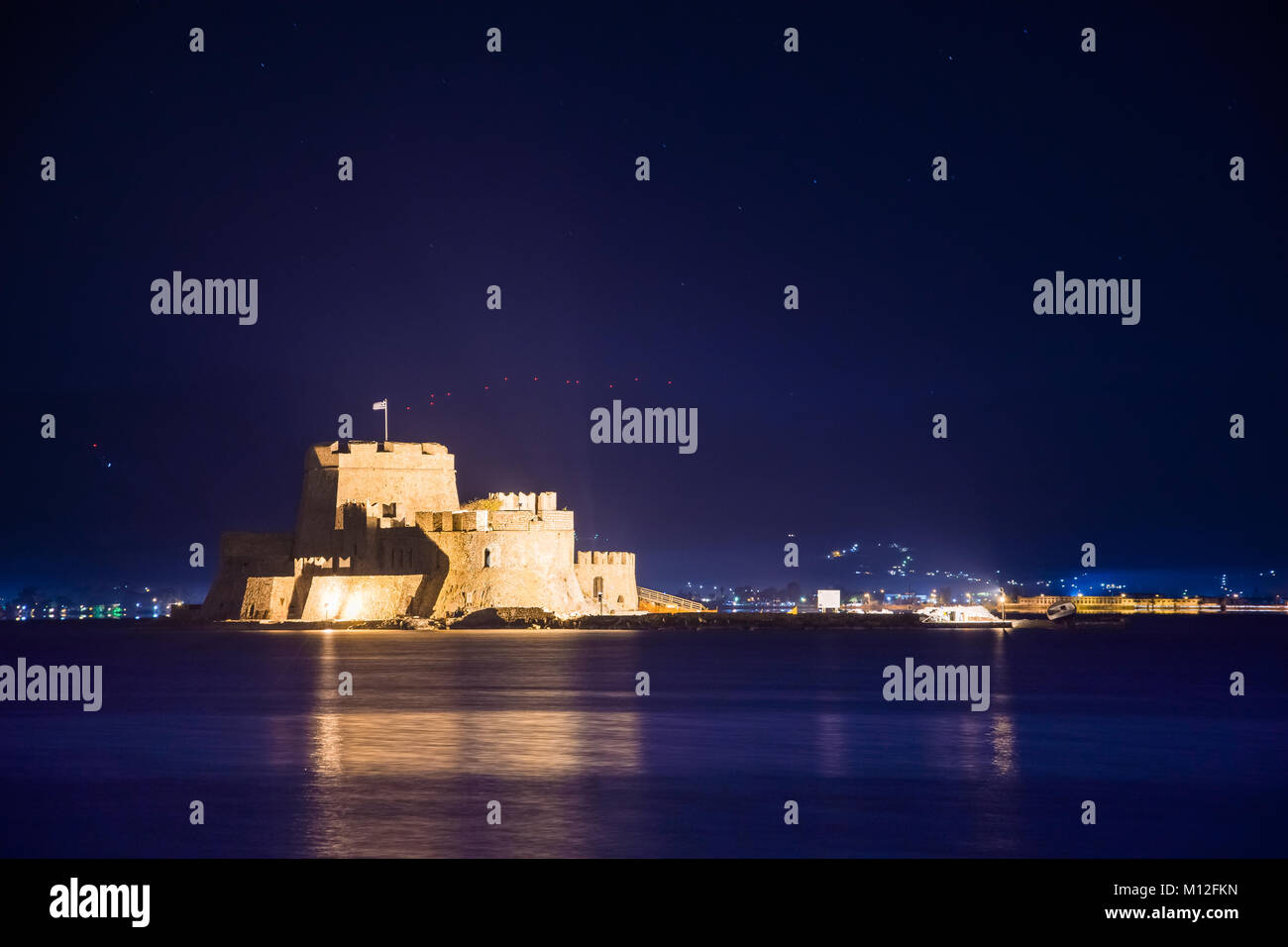 Allumé en vieille ville de Nauplie en Grèce avec des toits, petit port, le château de bourtzi, forteresse de Palamède de nuit. Banque D'Images
